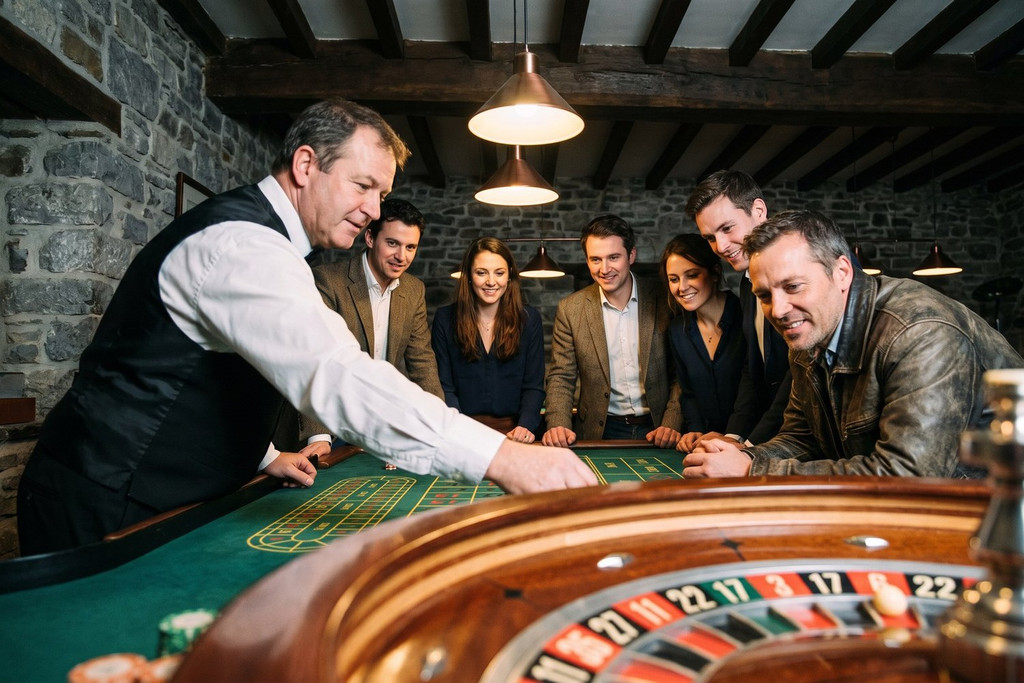 La bille de roulette est lancée devant six collègues attentifs, dans une salle en pierre et charpente